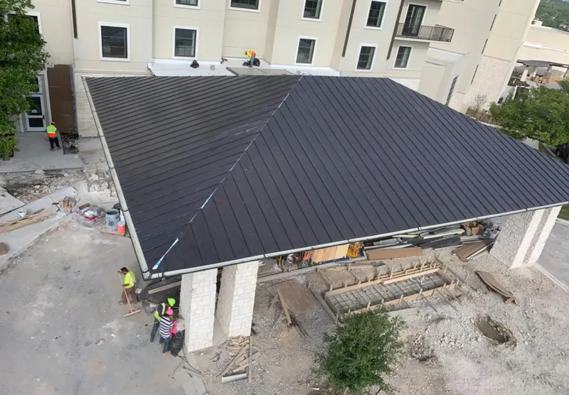 Metal roofing installation team working on a commercial building in New Castle